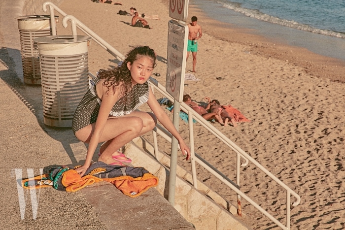러플 장식 원숄더 수영복은 Lisa Marie Fernandez by Net-a-Porter, 분홍색 플립플롭은 Adidas Originals, 비치 타월은 Hermes 제품.