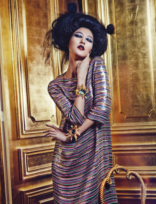 색색의 시퀸을 가로로 세밀하게 배치하여 마치 스트라이프 같은 느낌을 주는 큼직한 셔츠형 롱 드레스와 원석을 세팅한 금색 커프스는 모두 Schiaparelli Haute Couture by Marco Zanini 제품.