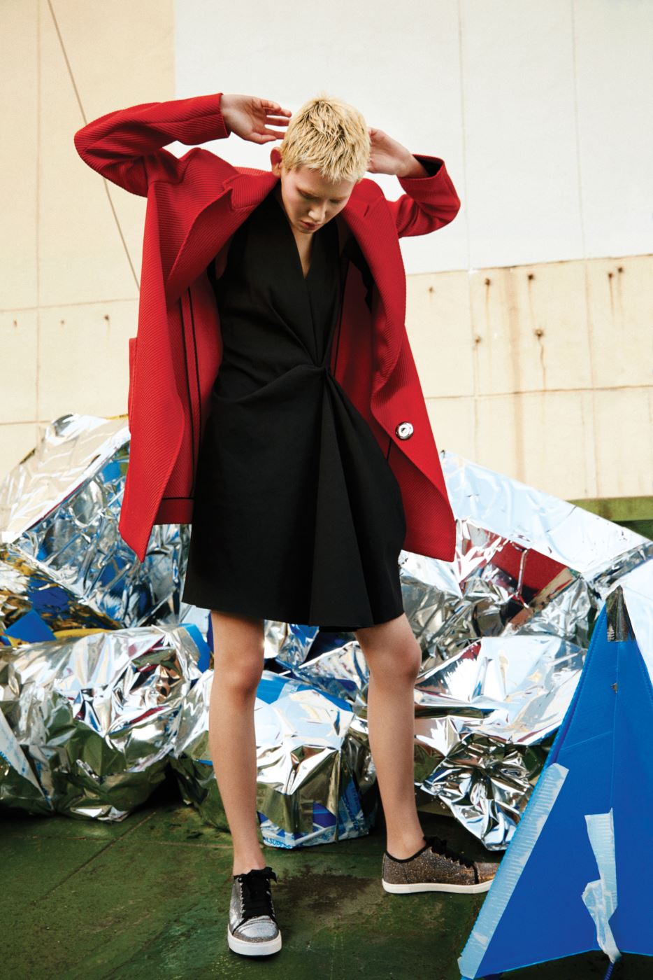 강렬한 빨간색 트윌 조직 코트와 보 장식 검정 드레스, 글리터 소재 스니커즈는 모두 Lanvin 제품.