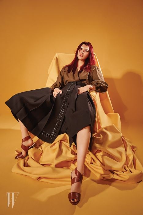 가죽 스티치 장식을 가미한 포켓이 독특한 드레스, 데님 효과를 준 실크 헤어피스, 여러 가지 색감이 섞인 T 바 샌들은 모두 Fendi  제품.