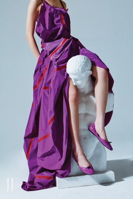 낙하산을 연상시키는 감각적인 주름 드레스, 스포티한 무드의 스트링이 달린 포라색 페이턴트 플랫 슈즈는 보테가 베네타 제품. 가격 미정.