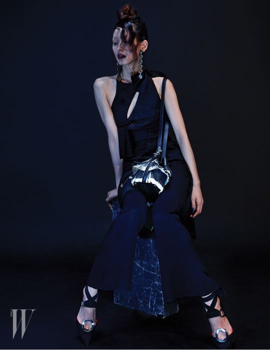 깊은 슬릿 장식 드레스는 Versace, 밑단이 나팔 모양으로 퍼지는 팬츠, 원형 메탈 장식 슈즈와 프린지 장식 버킷백은 모두 Proenza Schouler, 앤티크한 드롭 이어링은 Gucci 제품.