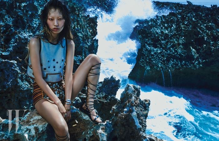 펀칭 장식이 특징인 스웨이드 소재 슬리브리스 톱과 아프리칸 무드의 브리프는 Bottega Veneta, 질감 처리가 독특한 뱅글과 반지는 모두 Jem & Pebbles, 터프한 글래디에이터 샌들은 Aldo 제품.