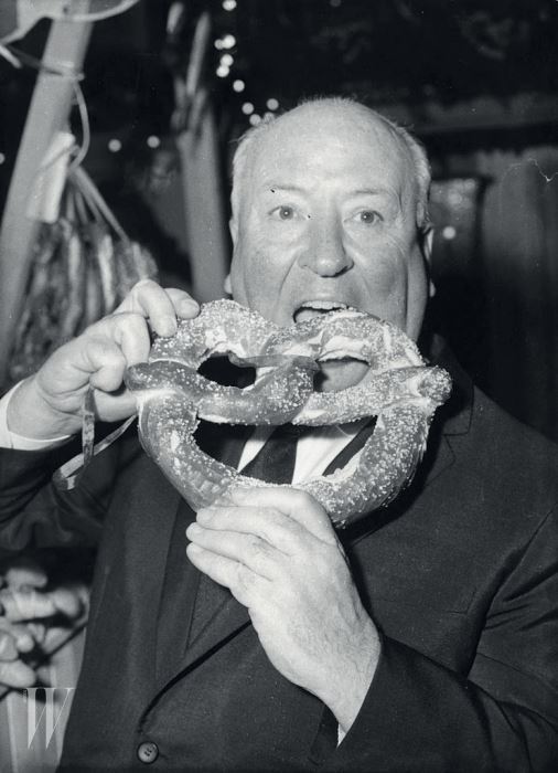 28th September 1960:  British film director Alfred Joseph Hitchcock (1899 - 1980) eats a pretzel at the premiere of 'Psycho'.  (Photo by Keystone/Getty Images)