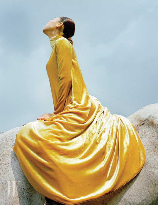 진한 노란색 벨벳 드레스는 Valentino 제품.