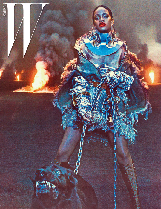 드레스는 Maison Margiela Haute Couture Created by John Galliano, 지퍼 장식 케이프는 리한나의 소장품. 귀고리는 Jennifer Fisher, 목 장식은 Rachel Freire, 뷔스티에는 Fannie Schiavoni, 갈색 벨트와 키 체인, 레이스업 부츠는 모두 Prada, 왼쪽 손에 낀 반지는 Fallon 제품.