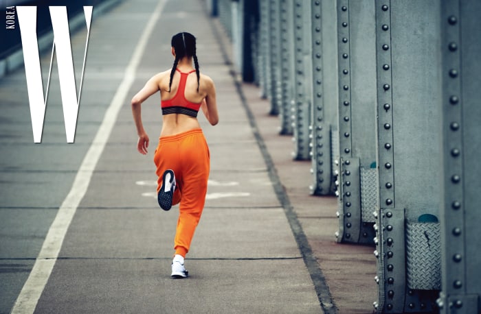 김설희가 입은 강렬한 색감의 브라와 러닝에 최적화된 러닝화, 양말은 모두 Nike, 경쾌한 오렌지 조거 팬츠는 Used Future 제품.