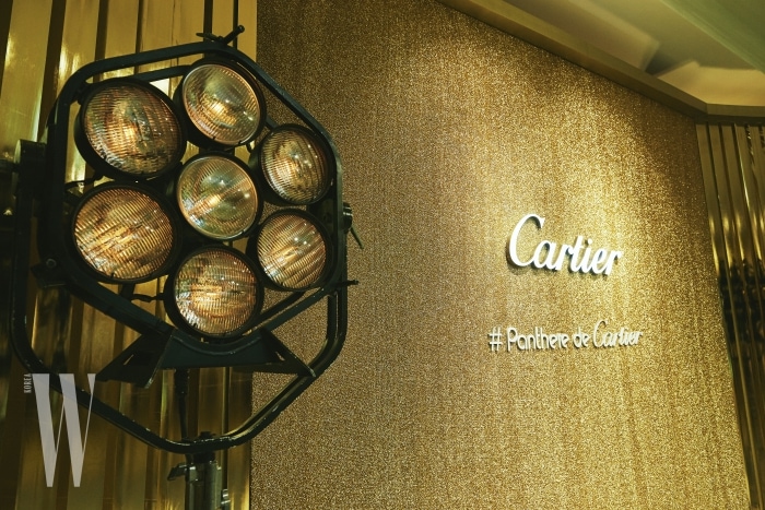 황금빛으로 글램하게 물든 파티 현장. #Panthere de Cartier라고 적힌 해시태그 문구가 눈길을 끈다.