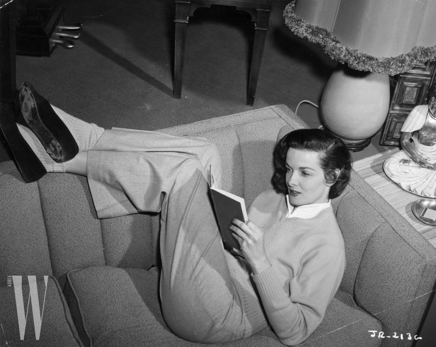 23rd August 1951:  American actress Jane Russell reading at home. width=