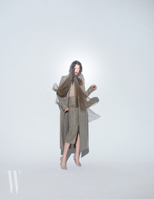 얇은 니트웨어와 줄무늬 롱 코트, 슬릿 장식 스커트, 펌프스는 모두 Max Mara 제품.