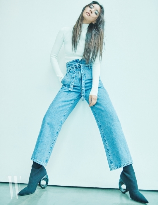 목 부분의 링 장식이 인상적인 니트 톱은 스텔라 매카트니 제품. 가격 미정. 허리를 매듭으로 묶는 하이웨이스트 데님 팬츠는 커런트/엘리엇 제품. 45만원. 기하학적인 굽이 돋보이는 부츠는 버버리 제품. 가격 미정.