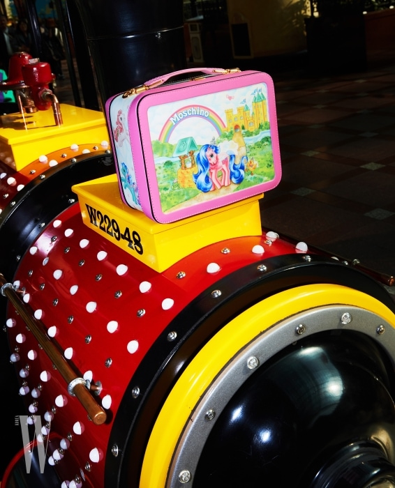 기차 위에 놓인 포니 캐릭터 사각 백은 모스키노 제품. 1백14만원.