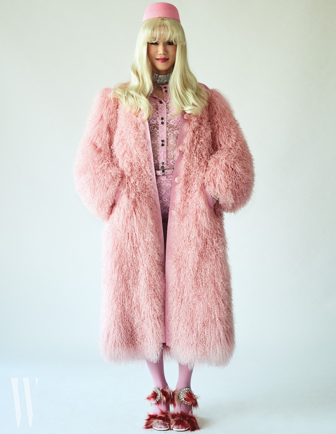 퍼포머 랑리가 입은 핑크색 퍼 코트, 안에 입은 레이스 보디슈트와 벨트는 Nina Ricci, 크리스털 초커는 Miu Miu, 퍼 장식 샌들은 Prada 제품. 핑크색 모자는 에디터 소장품.