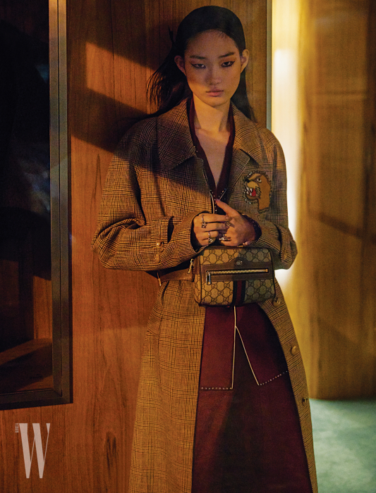 체크무늬 코트, 실크 파자마 셔츠와 팬츠, 허리에 착용한 가방과 반지들은 모두 Gucci 제품.