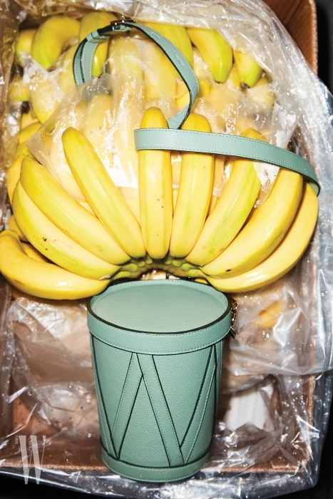 바나나 상자에 들어 있는 에메랄드그린 컬러의 둥근 박스 백은 니나리치 제품. 