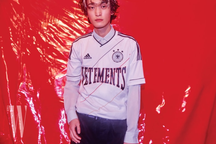 축구 유니폼은 Nss Magazine, 안에 입은 시스루 셔츠와 검은색 팬츠는 Berluti, 스트랩 벨트는 Louis Vuitton 제품.