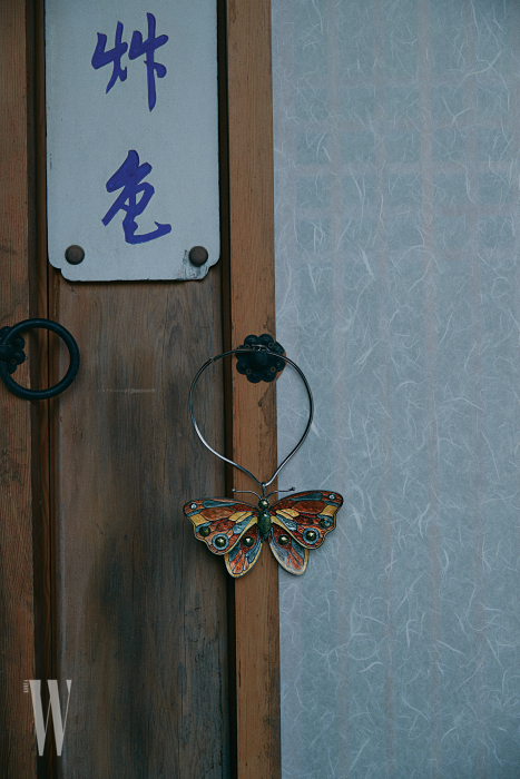 자개 조각을 맞춰 완성한 나비 목걸이는 보테가 베네타 제품.