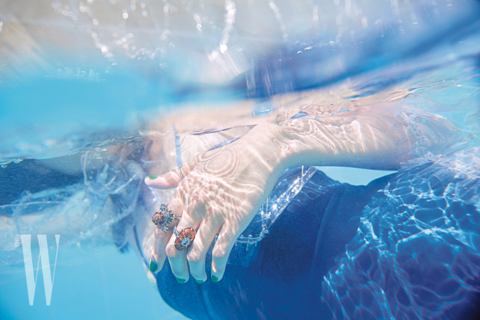 자연스러운 날염 무늬가 돋보이는 푸른색 수영복은 샤넬 제품. 70만원대. 손가락에 낀 입체적인 반지는 보테가 베네타 제품. 60만원대.