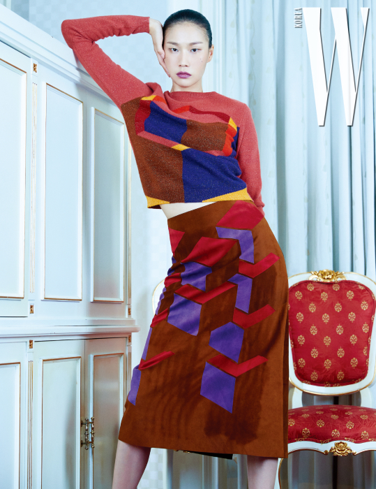 그래픽 패턴이 돋보이는 니트 스웨터와 스웨이드 소재 스커트는 Bottega Veneta 제품.