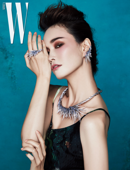 가장무도회의 가면을 모티프로 화이트 골드에 블루 사파이어와 다이아몬드를 화려하게 세팅한 목걸이와 귀고리, 반지는 모두 Tasaki 제품. 신비로운 프린트 드레스는 Prada 제품.
