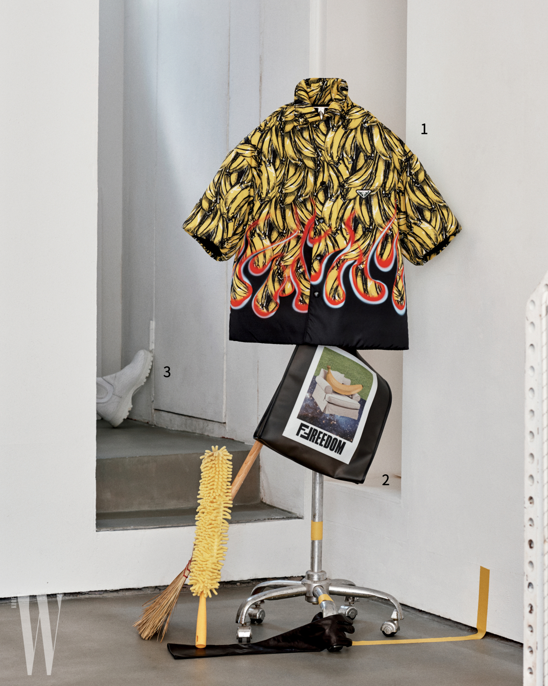 1. 바나나와 불꽃 패턴 셔츠는 프라다 제품. 가격 미정. 2. 사진과 그래픽이 콜라주된 비닐 백은 펜디 제품. 가격 미정. 3. 문 뒤에 놓인 하얀색 워커는 프라다 제품. 가격 미정.