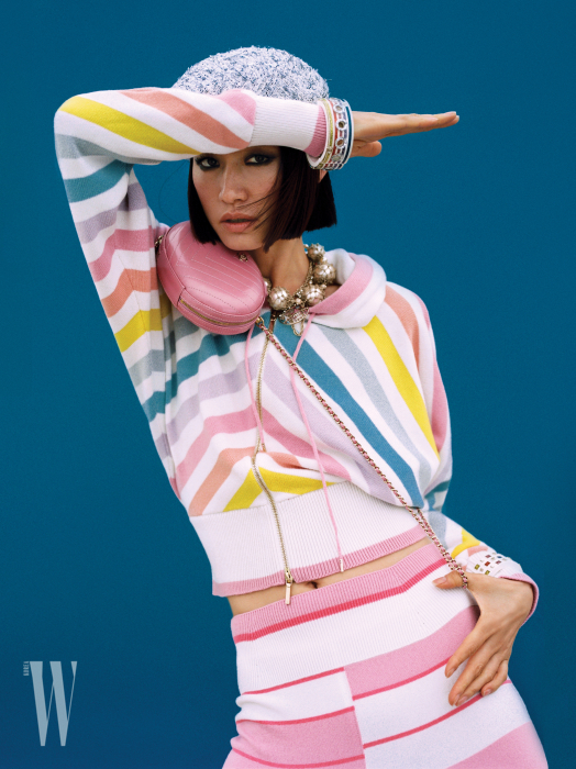 달콤한 색이 조합된 줄무늬 캐시미어 집업 카디건과 스커트, 분홍색 양가죽 핸드백, 메탈과 구슬 장식 목걸이, 컬러풀한 뱅글, 베레는 모두 Chanel 제품.
